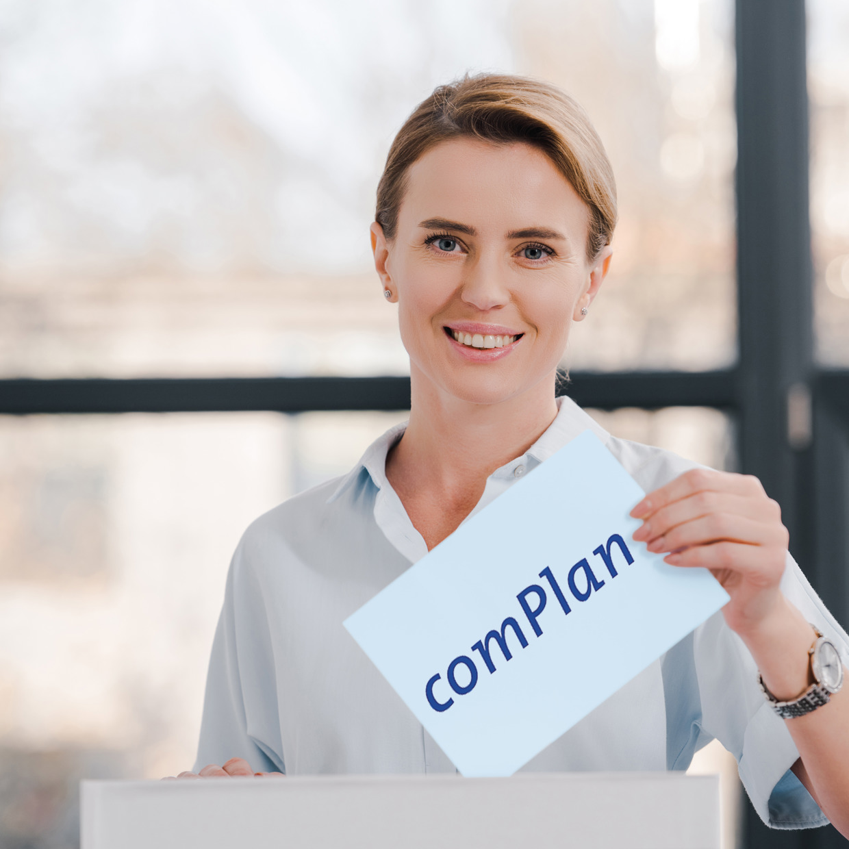 Frau mit Wahlcouvert mit comPlan Loga